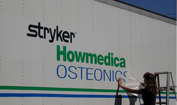 Vehicle Lettering Installation Vinyl being applied on a truck