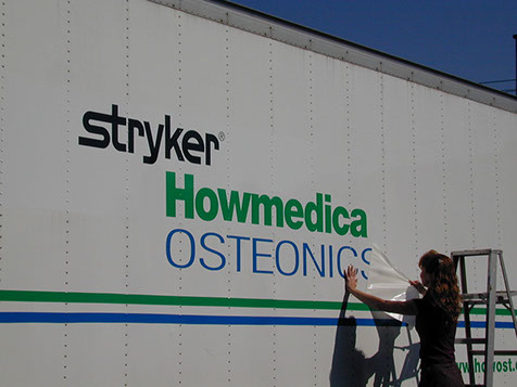 Vehicle Lettering Installation Vinyl being applied on a truck
